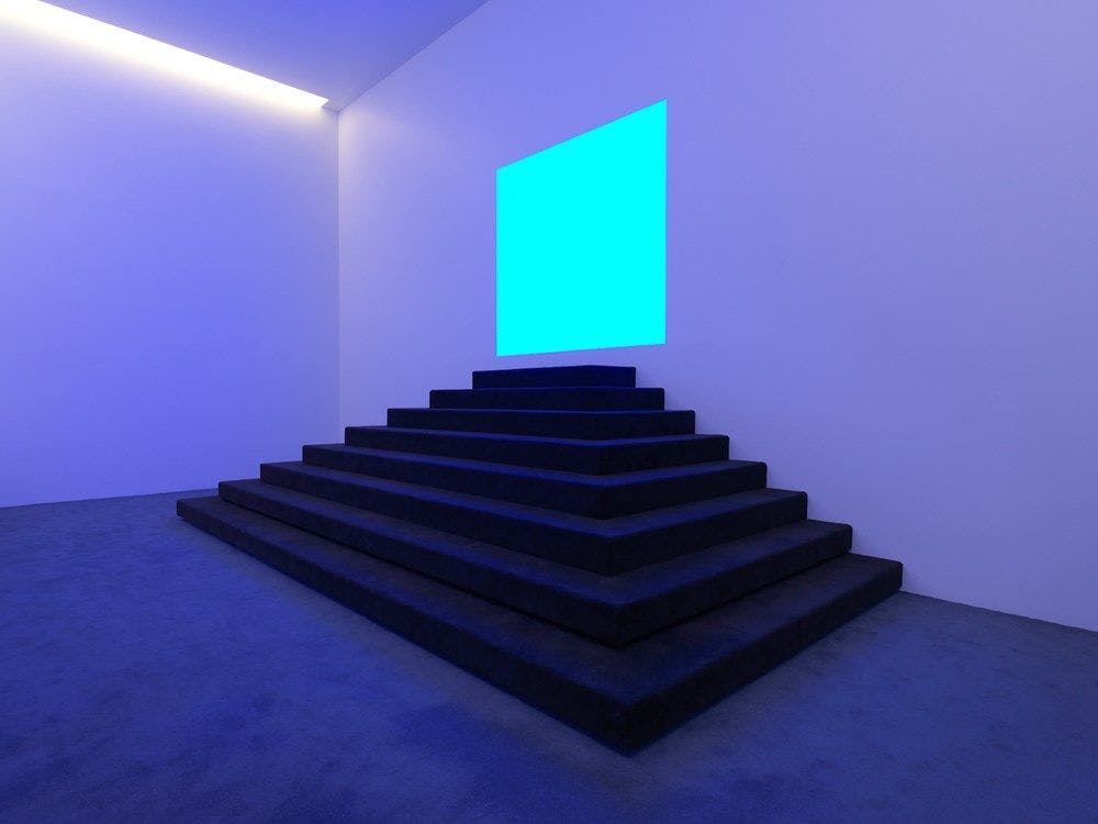 A staircase leads to a blue lit square,