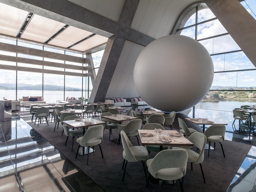 A large white Sphere with restaurant seating around it.
