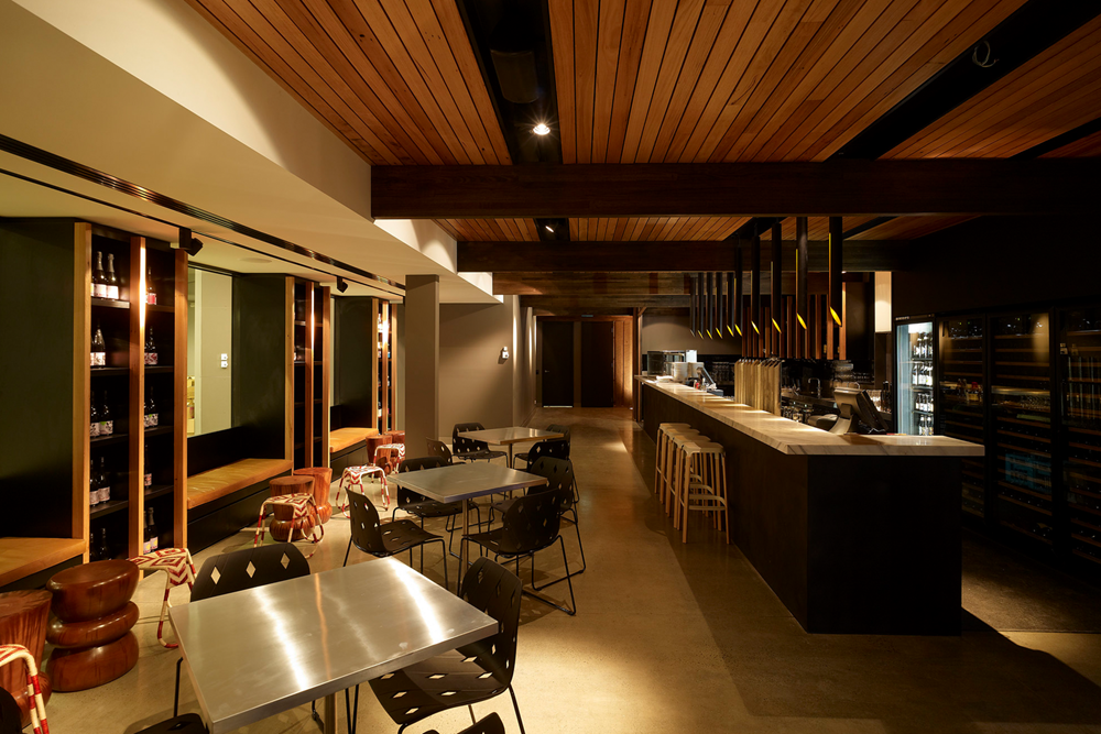 Steel tables, leather benches, wood ceiling of the Wine Bar