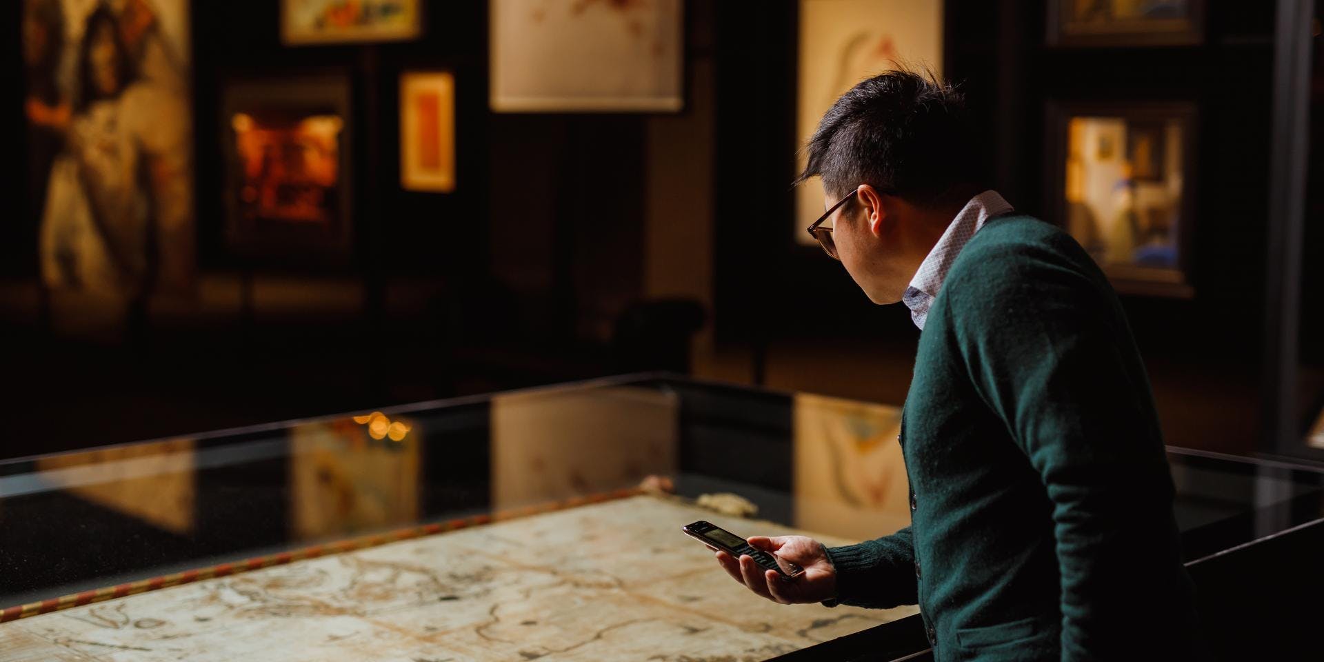 A person looking at a work on display with The O in their hand