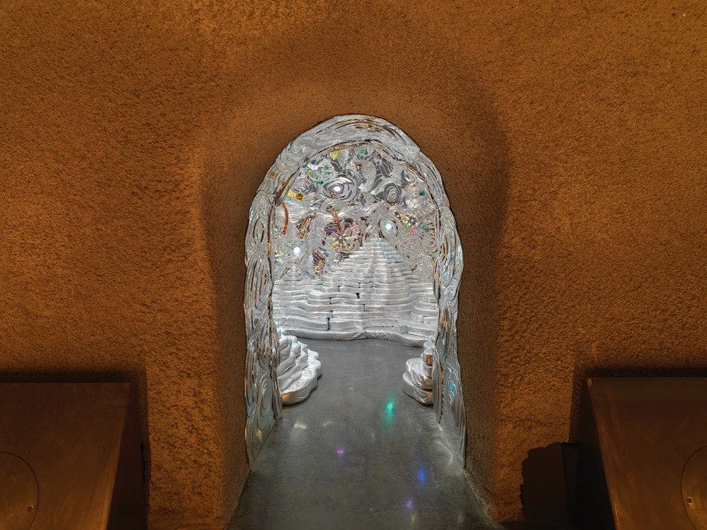 View of Grotto through an arched sandstone doorway.