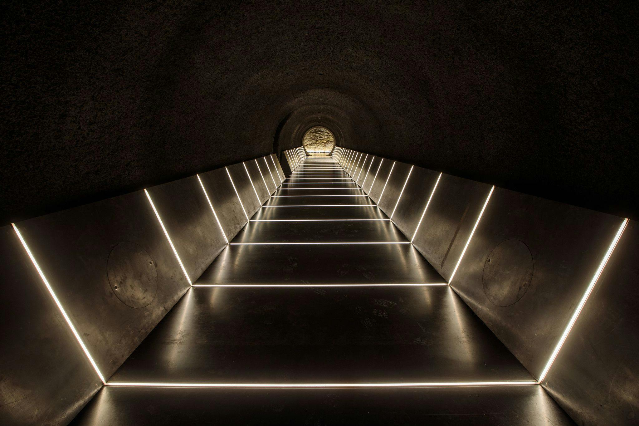 A long dark tunnel lit by illuminated strips