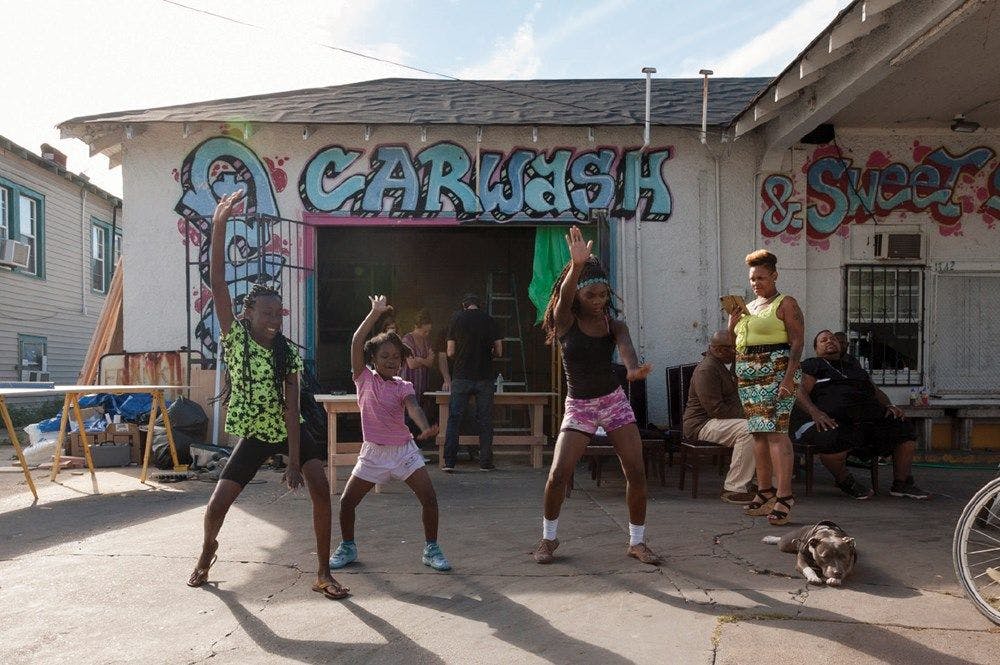 Young people dance outside a carwash