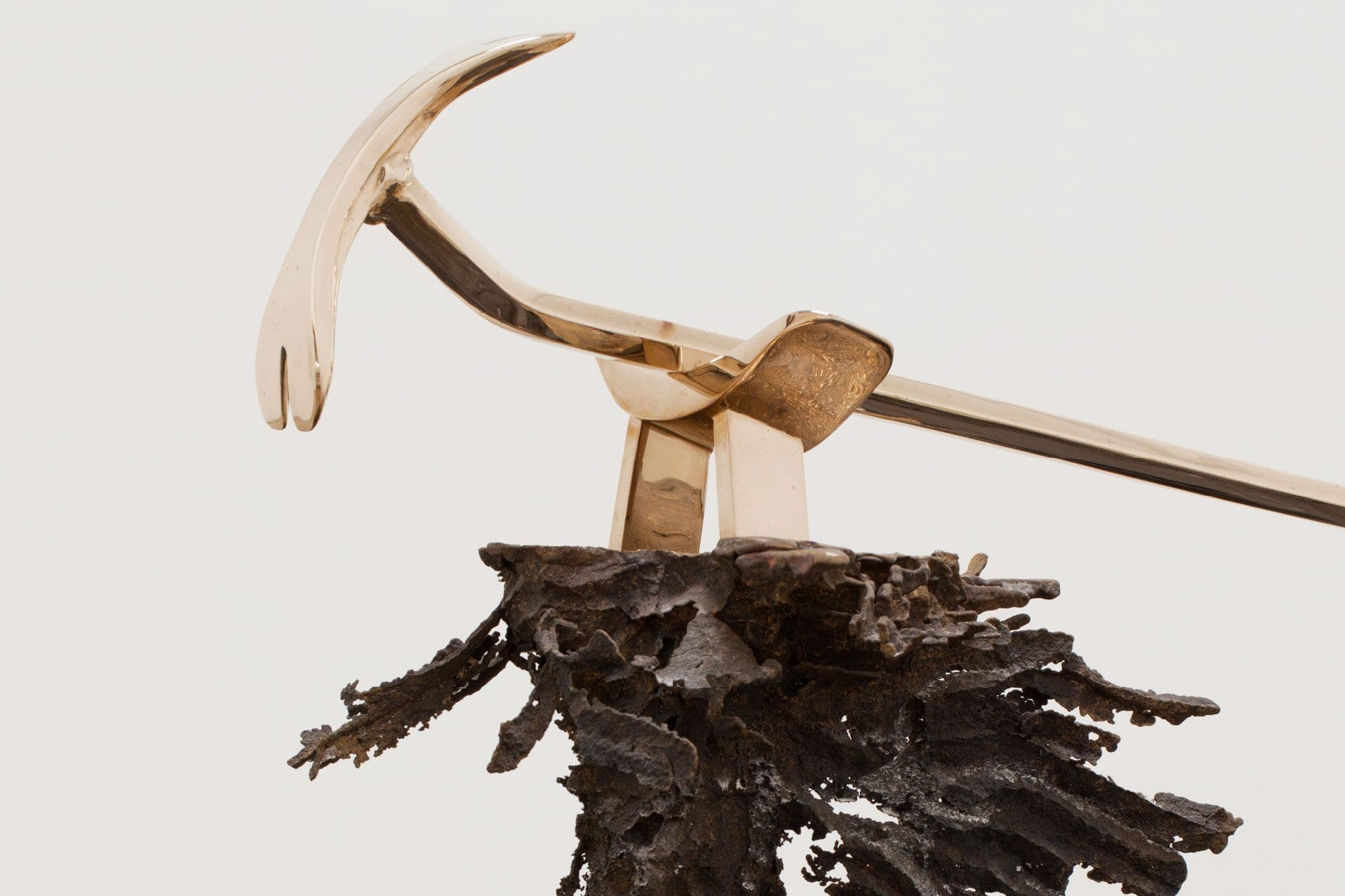 Copper coloured tool on a gnarled metallic stand.