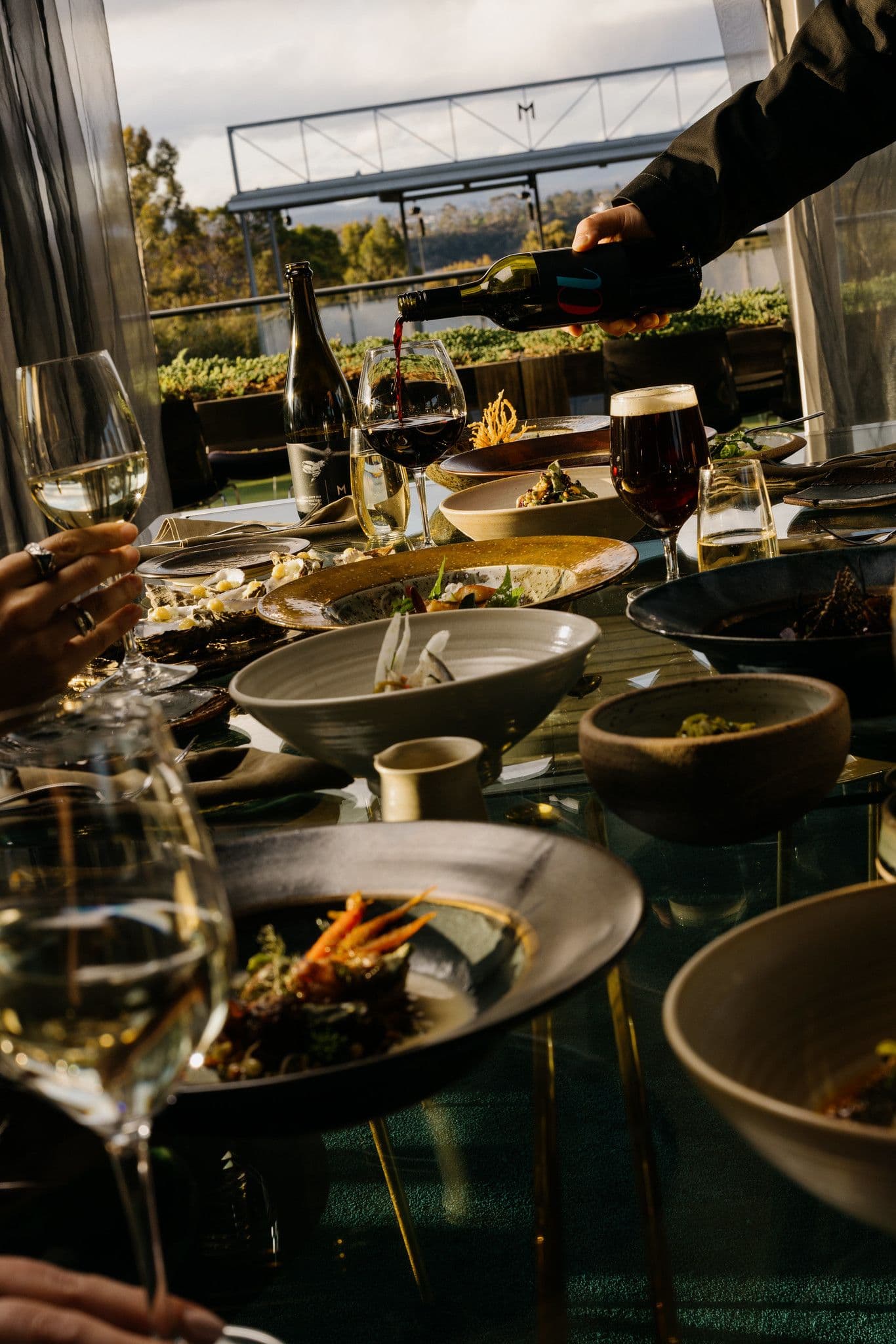 Many delicious plates of food, with beer and Moorilla pinot noir being served