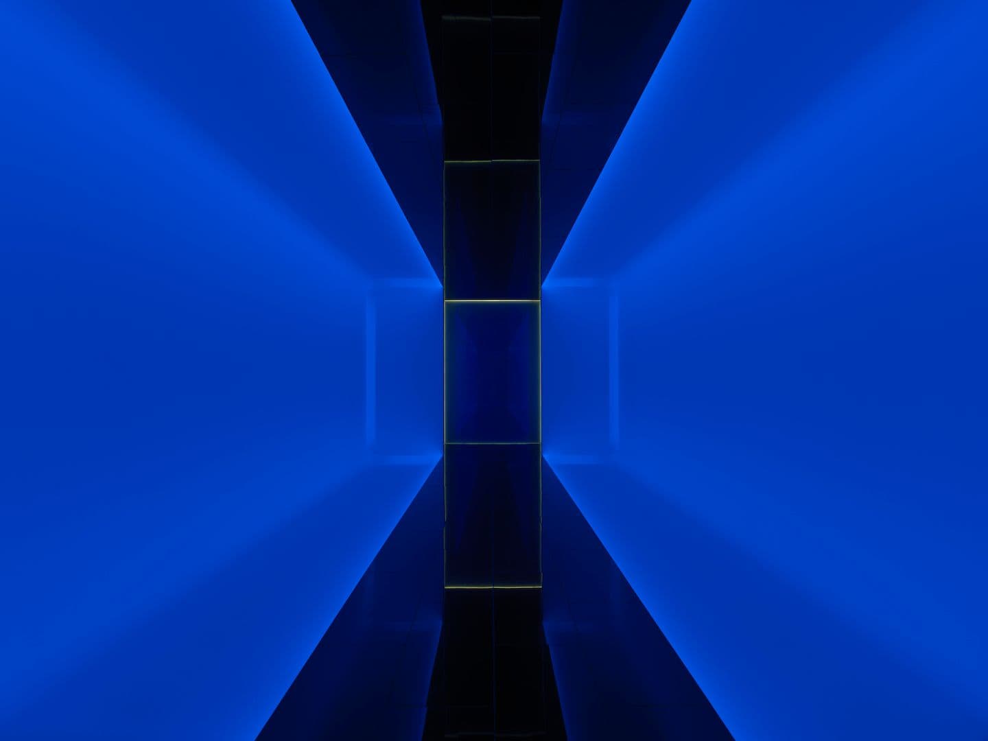 A reflective walkway lit in blue hues.